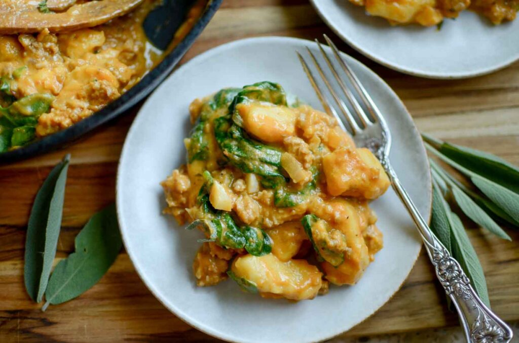 Pumpkin gnocchi with Italian sausage and spinach on a plate