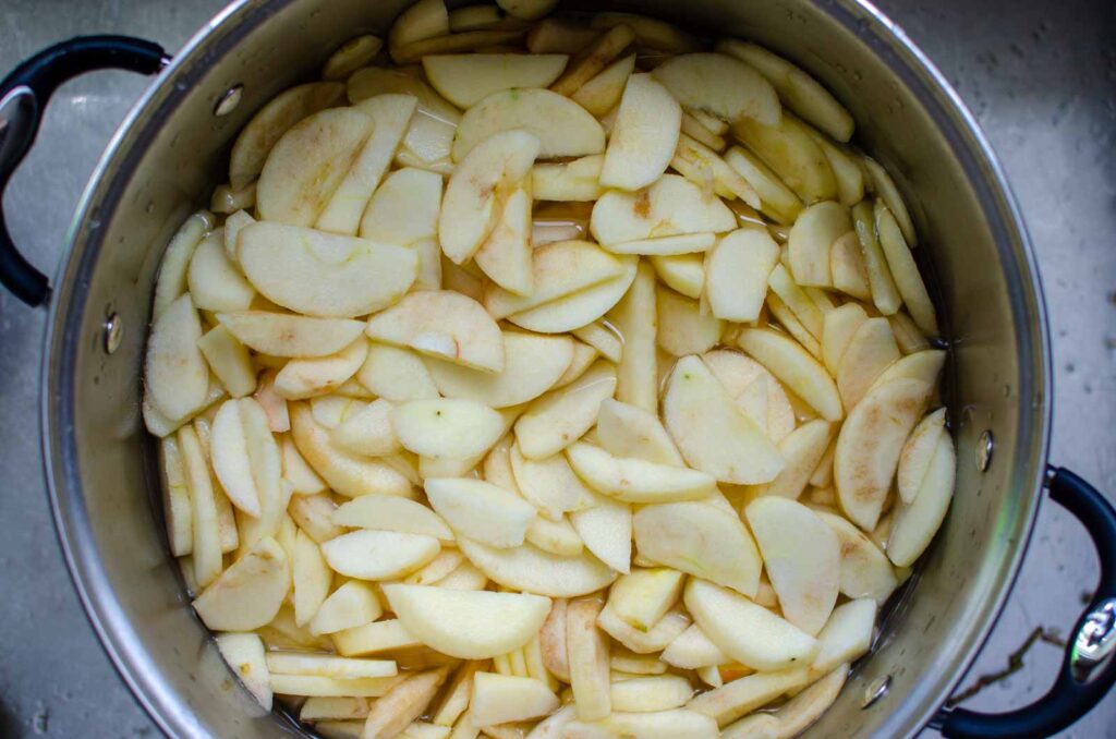 apple slices in a large pot of lemon water