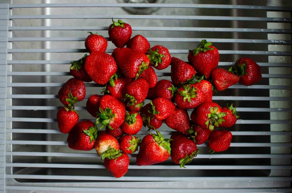 strawberries on drying rack over sink