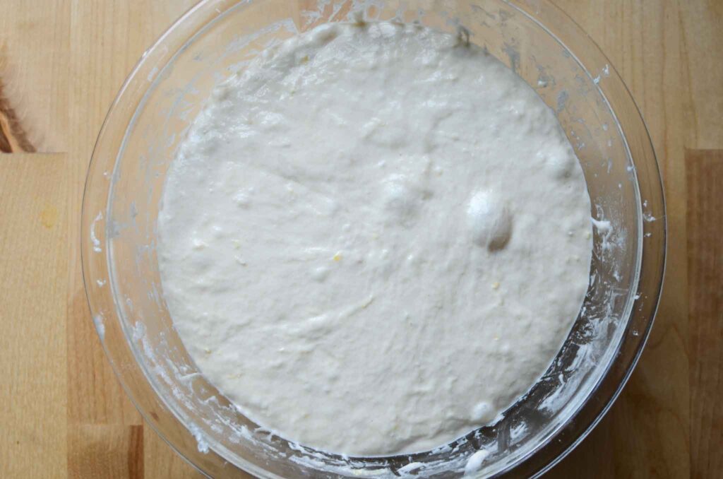 a bowl of lemon focaccia dough that is risen