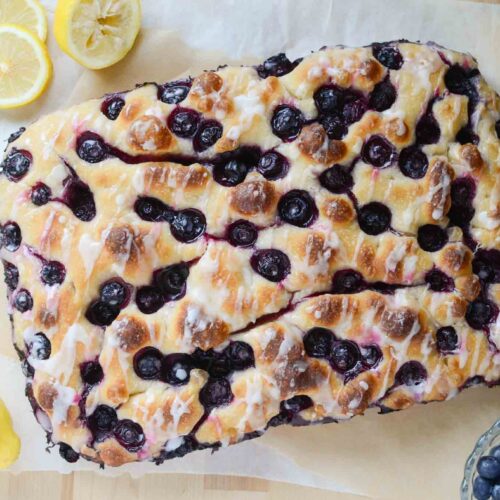 sourdough lemon blueberry focaccia bread with cut lemons