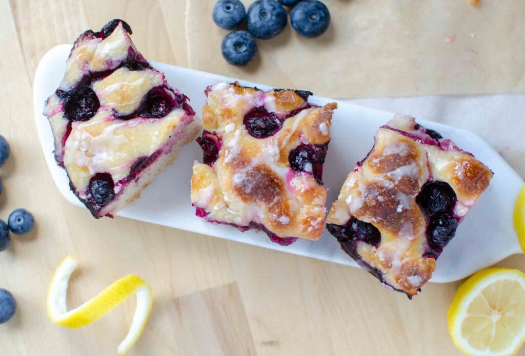 pieces of easy sourdough lemon blueberry focaccia bread on stone serving tray