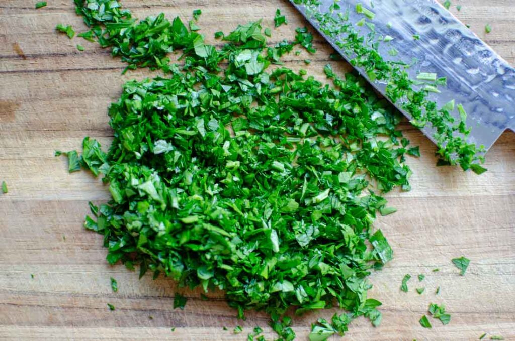 chopped parsley on wooden cutting board