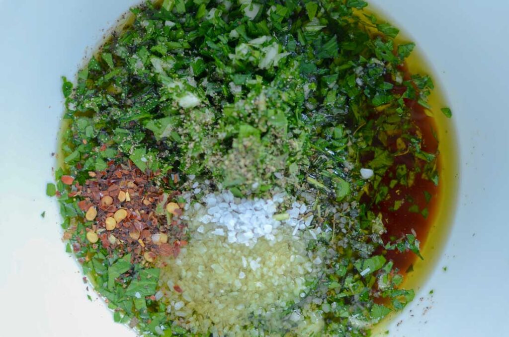 chimichurri sauce ingredients in a white bowl