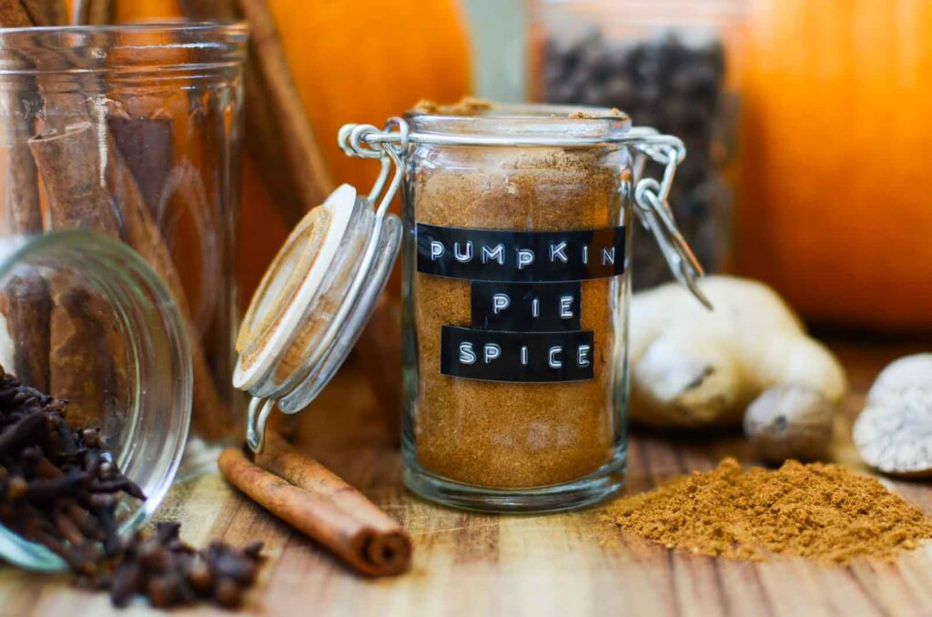 pumpkin pie spice, and other whole spices on a wood cutting board