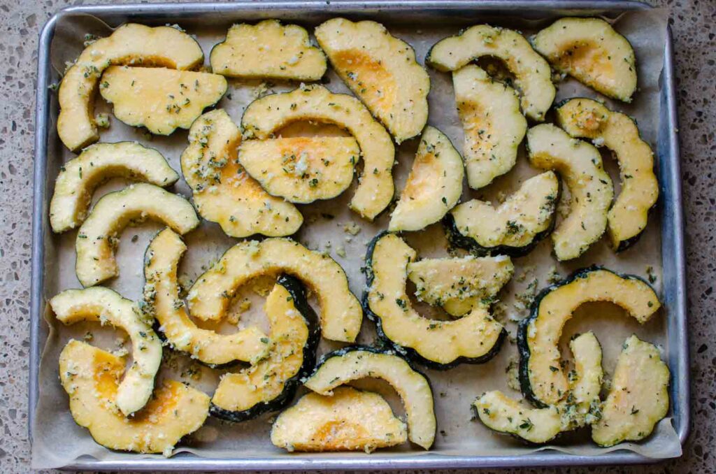 slices of acorn squash on a baking sheet pan