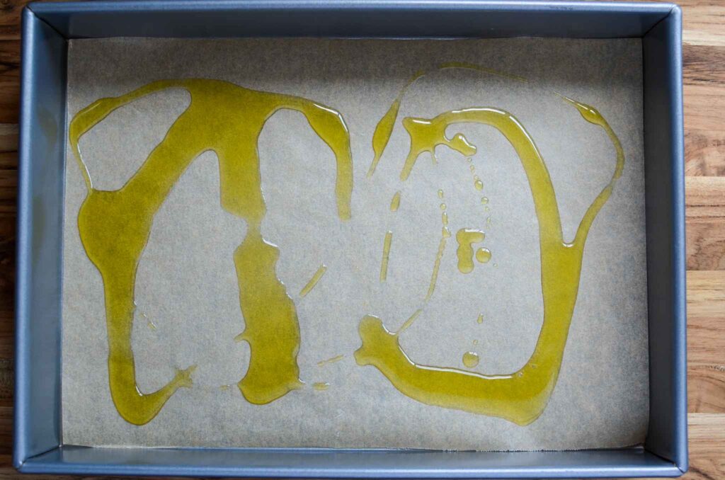 olive oil in parchment lined baking pan