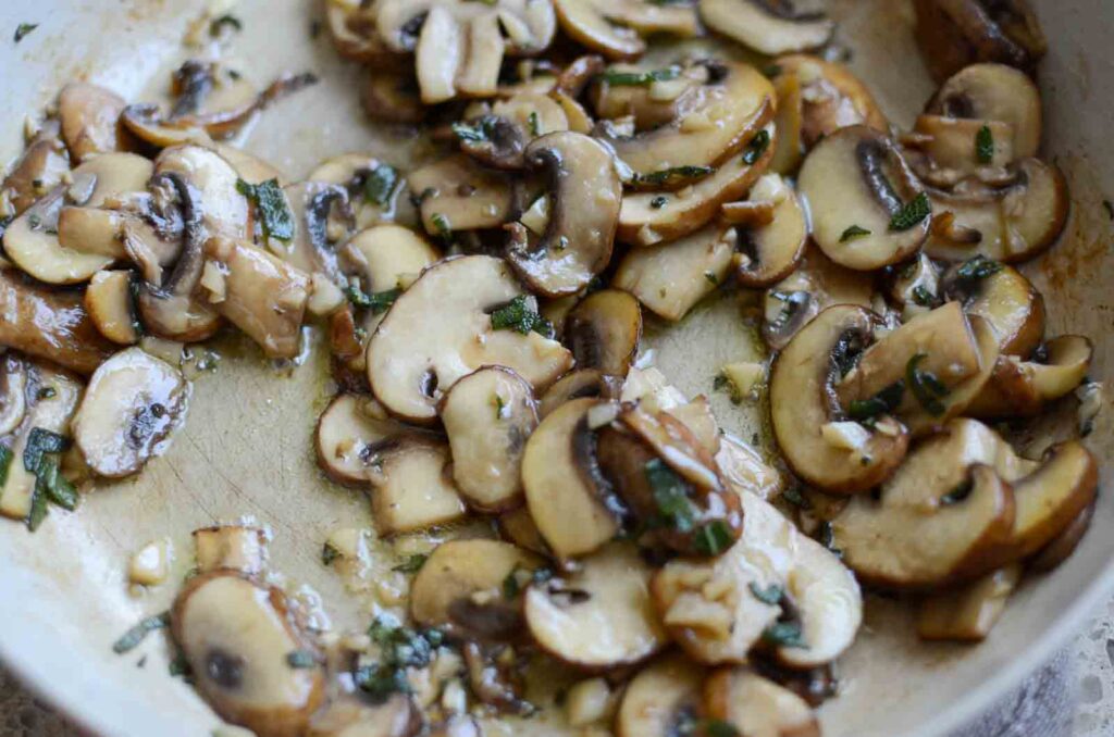 Sauteed mushrooms, garlic, and sage in frying pan