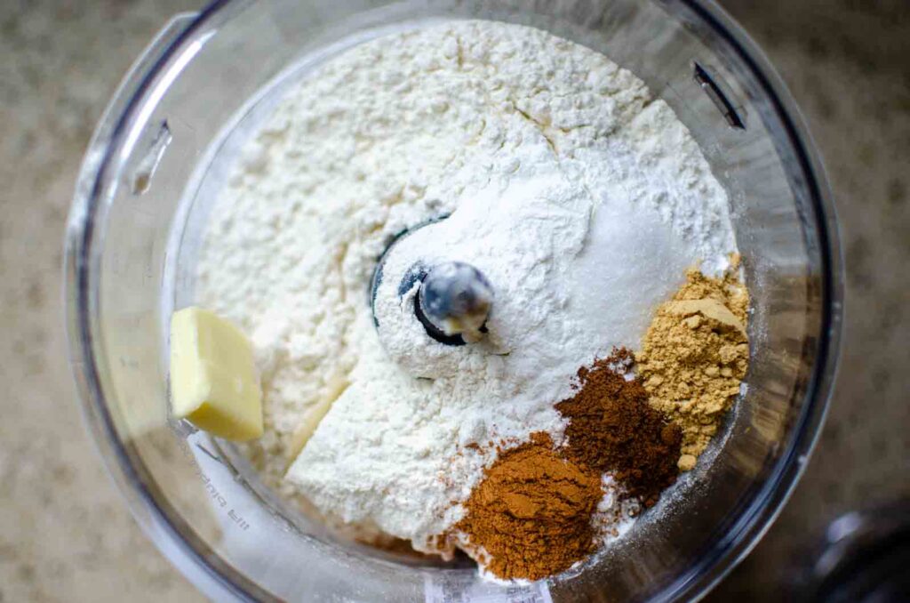 adding dry ingredients in the bowl of a food processor