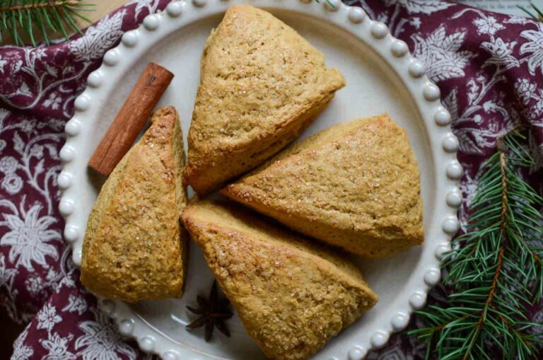 gingerbread scones on a plate with a cinnamon stick