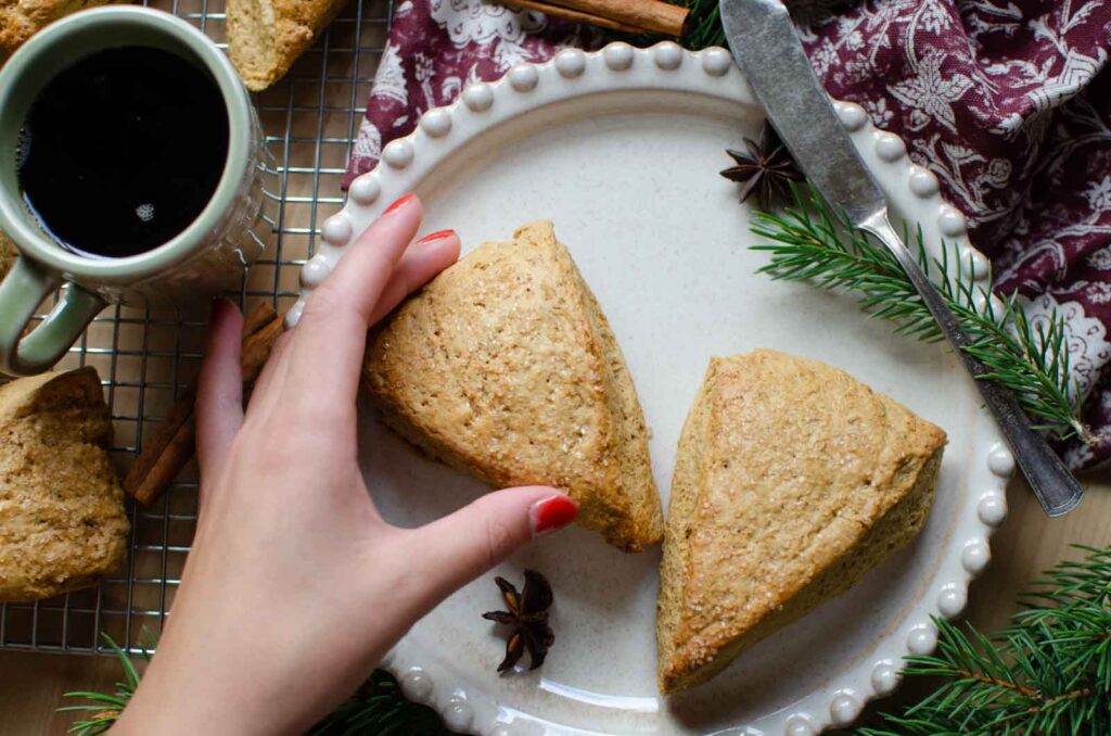 grabbing a sourdough gingerbread scone from a plate