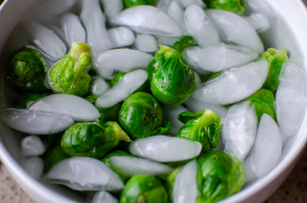 submerged blanched brussels sprouts in ice water