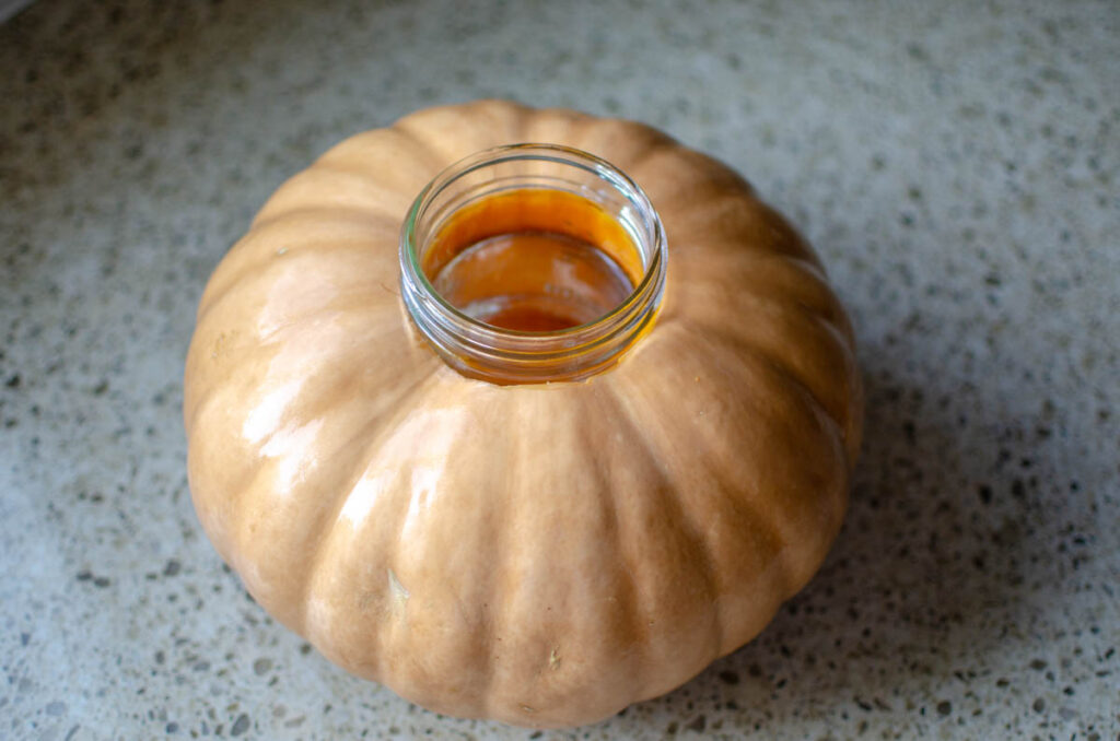 the mason jar set inside of a pumpkin