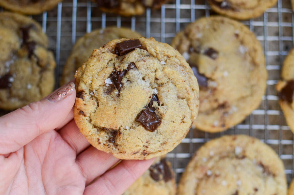 holding a single brown butter sourdough chocolate chip cookie