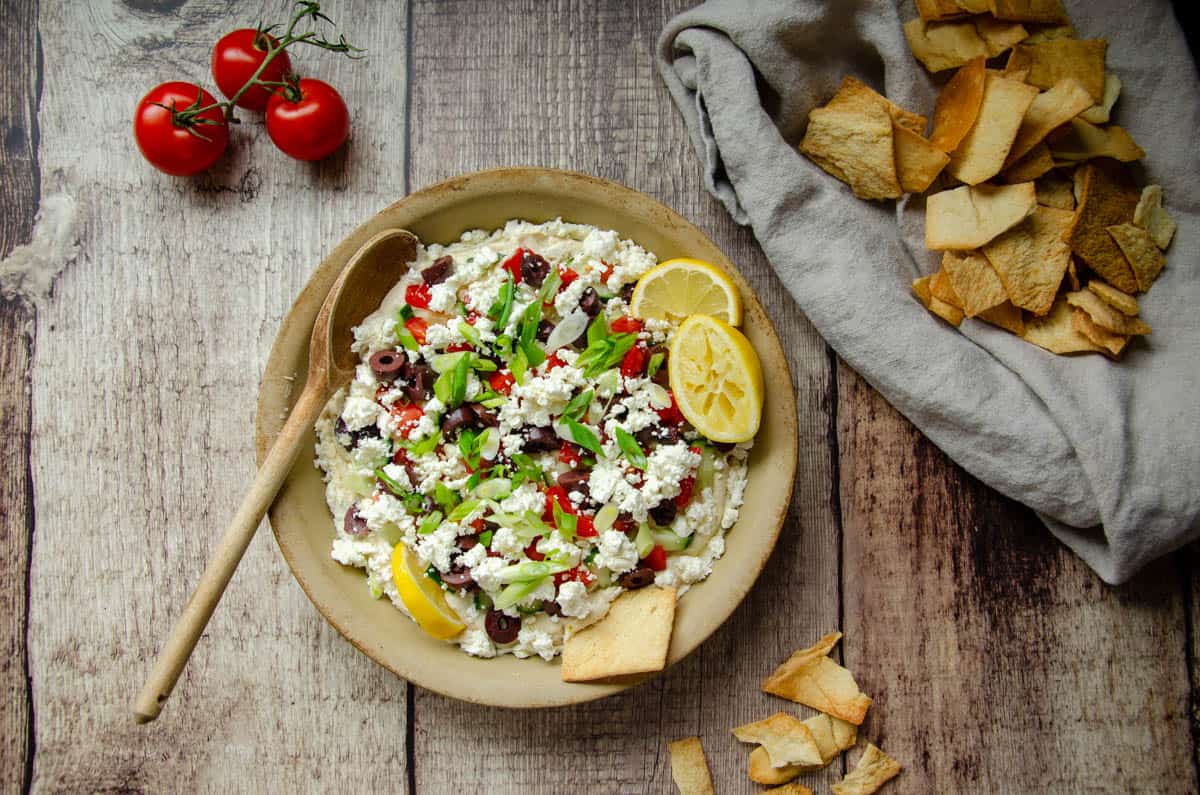 Mediterranean hummus dip in stone dish with pita chips