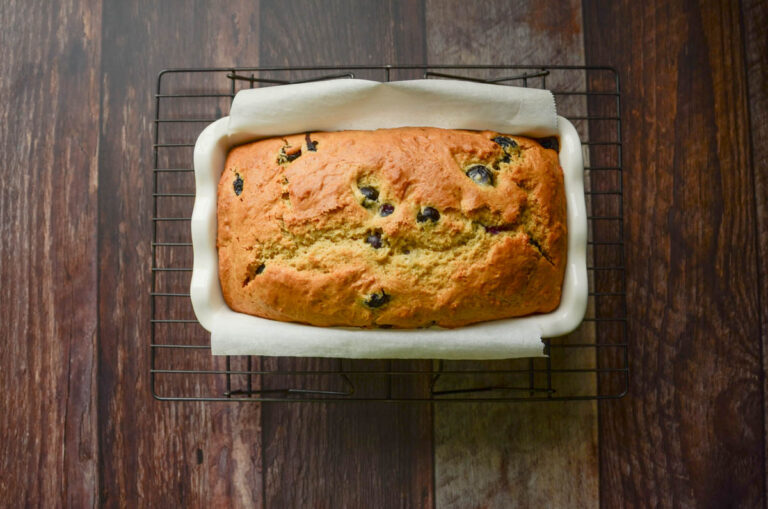 sourdough lemon blueberry bread in a parchment lined loaf pan