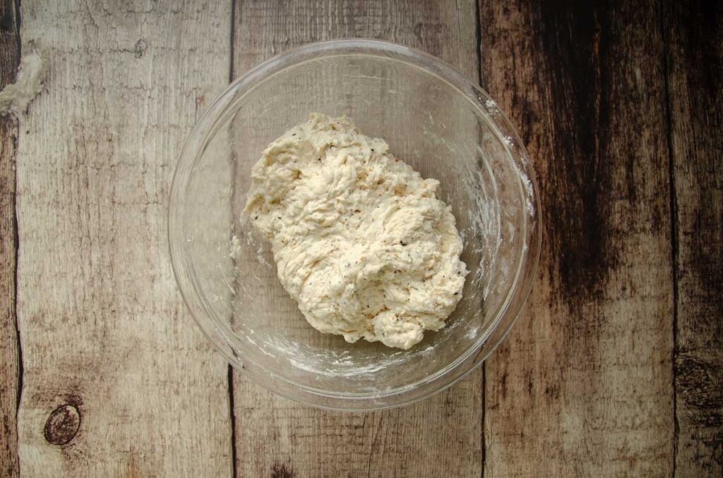 mixed ingredients for sourdough bread in a glass bowl 