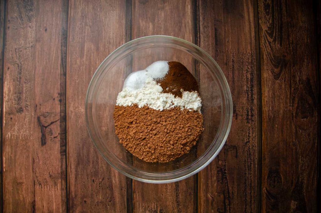 Dry ingredients for double chocolate sourdough cookies in a glass bowl.