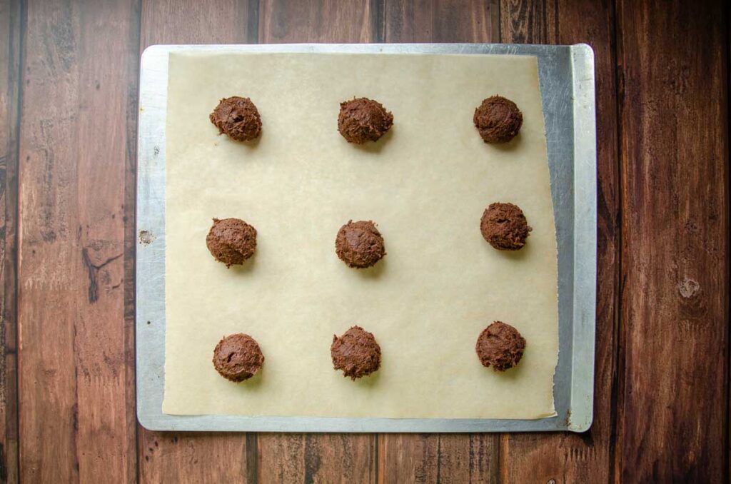 scooped cookie dough on a parchment lined baking sheet.