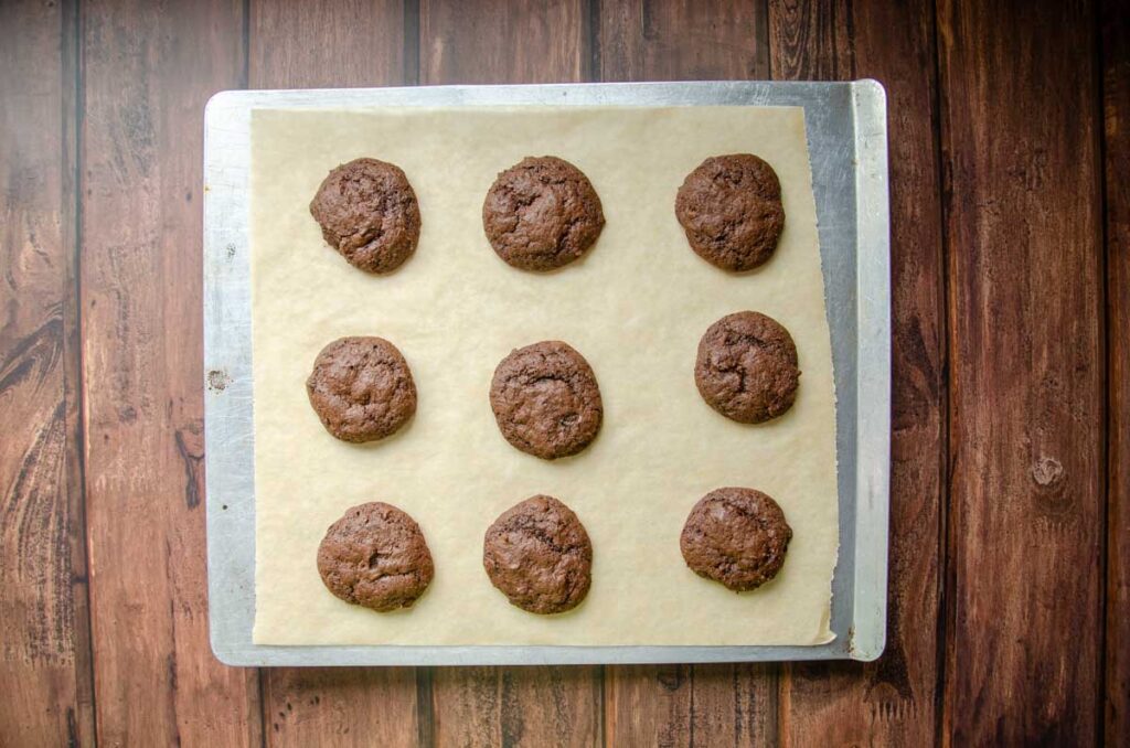 baked double chocolate cookie dough on a parchment lined baking sheet.