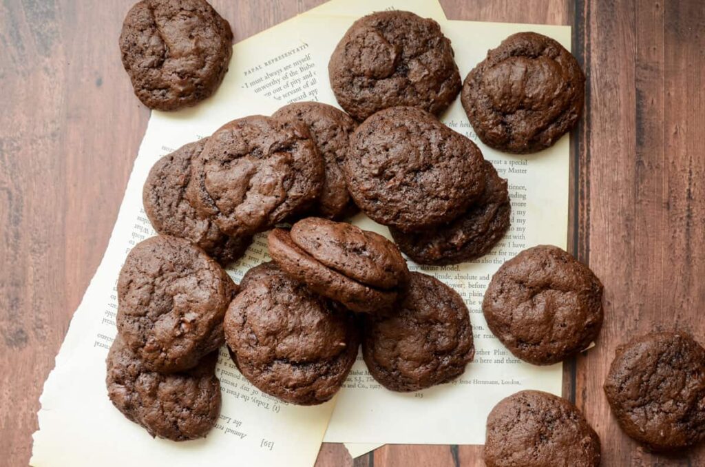 double chocolate sourdough cookies scattered on book pages 