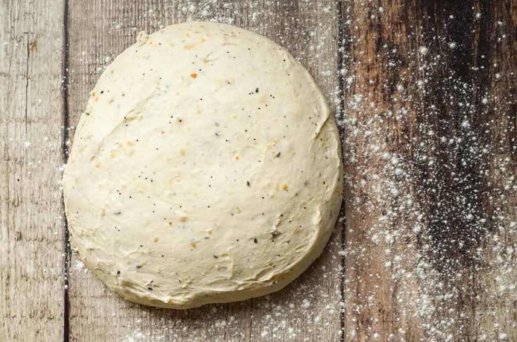 bread dough resting on lightly floured work surface