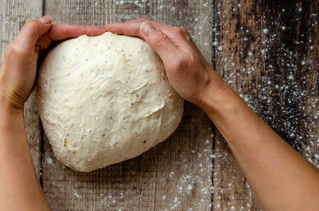 cupping the dough to shape into a tight ball