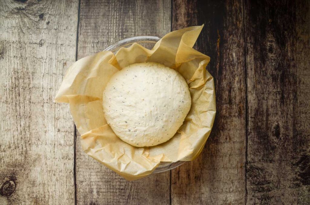 everything sourdough bread proofing in parchment lined bowl