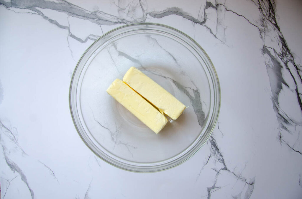 two sticks of unsalted butter in a glass bowl