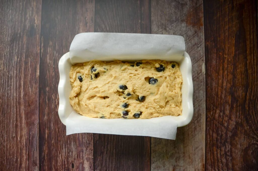 blueberry bread in parchment lined loaf pan