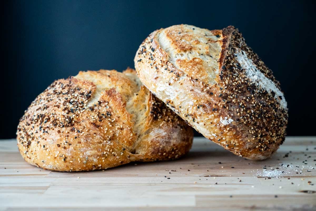 two loaves of sourdough everything bread loaves stacked together