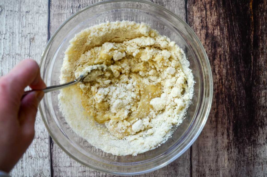 stirring the almond flour into the wet ingredients in a glass bowl