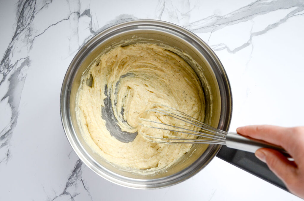 Whisking a thickened bechamel in saucepan