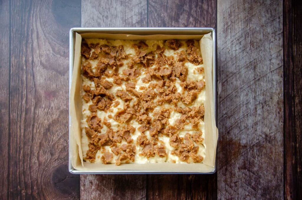 layering the crumble mixture on top of the sourdough coffee cake batter