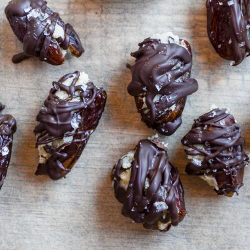 cookie dough stuffed dates covered in chocolate with a sprinkle of flaky sea salt