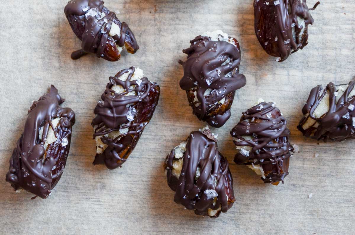 cookie dough stuffed dates covered in chocolate with a sprinkle of flaky sea salt