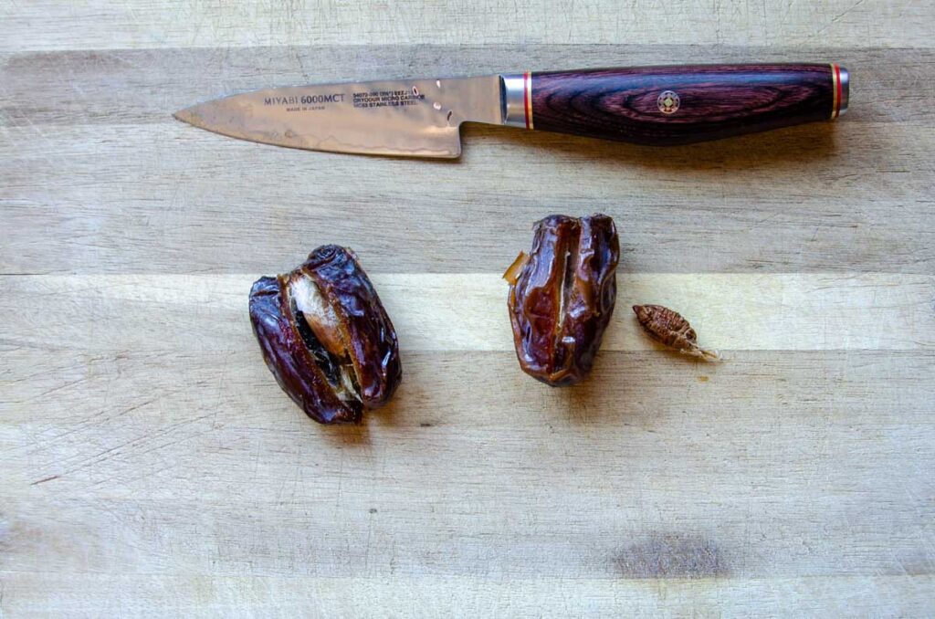 dates cut open with a knife with the pit removed