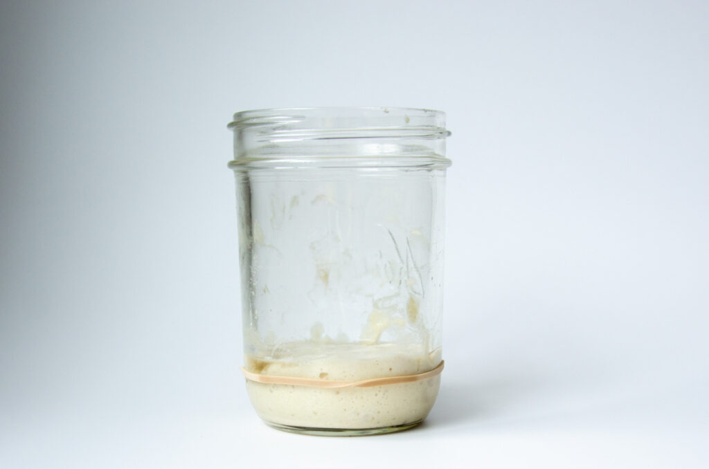 a jar of sourdough starter with a rubber band around it.