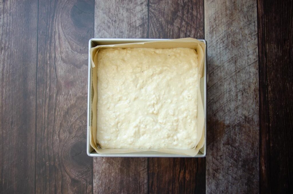 sourdough coffee cake batter in a parchment lined 9x9 square pan