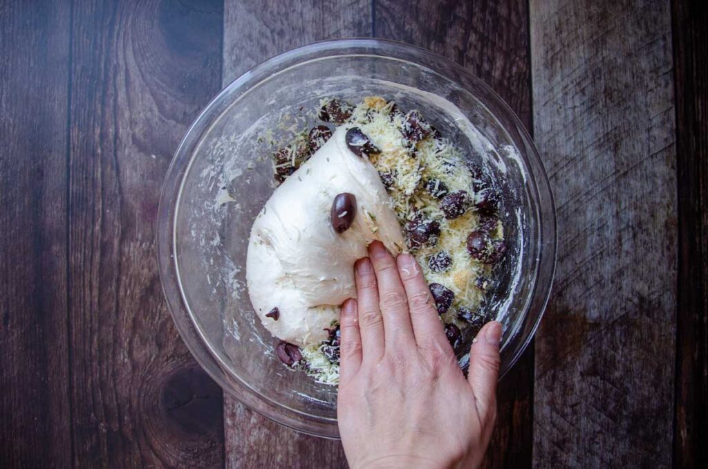 folding olives, cheese, and herbs into the sourdough bread dough