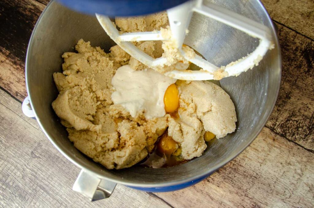 Adding eggs, sourdough discard, and vanilla extract to creamed butter mixture.