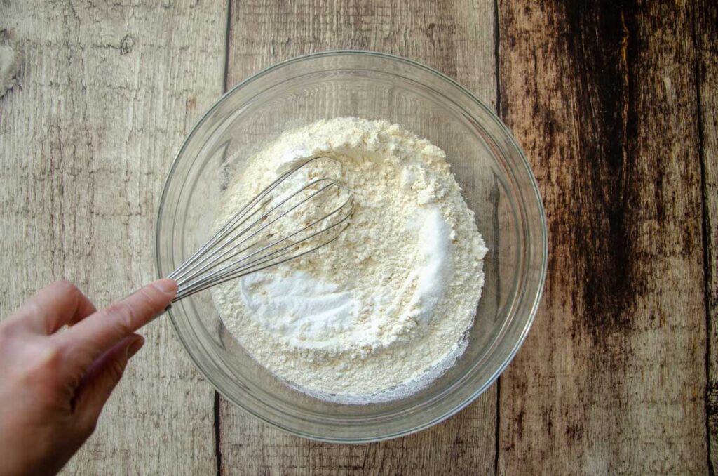 whisking dry ingredients together in a glass bowl