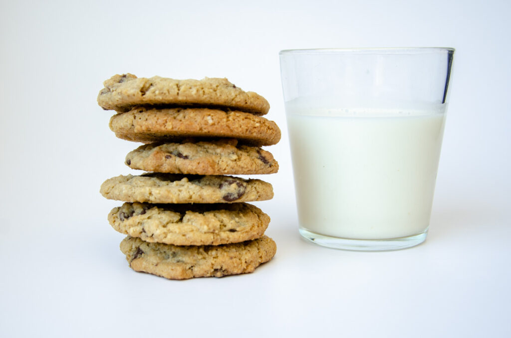 a stack of sourdough oatmeal chocolate chip cookies next to a glass of milk