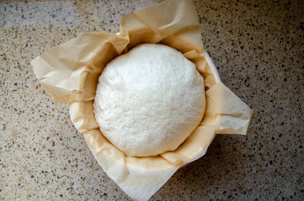 sourdough dough in a parchment lined banneton