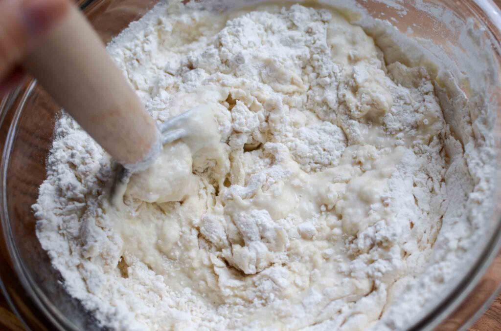 Mixing sourdough bread dough in a glass bowl