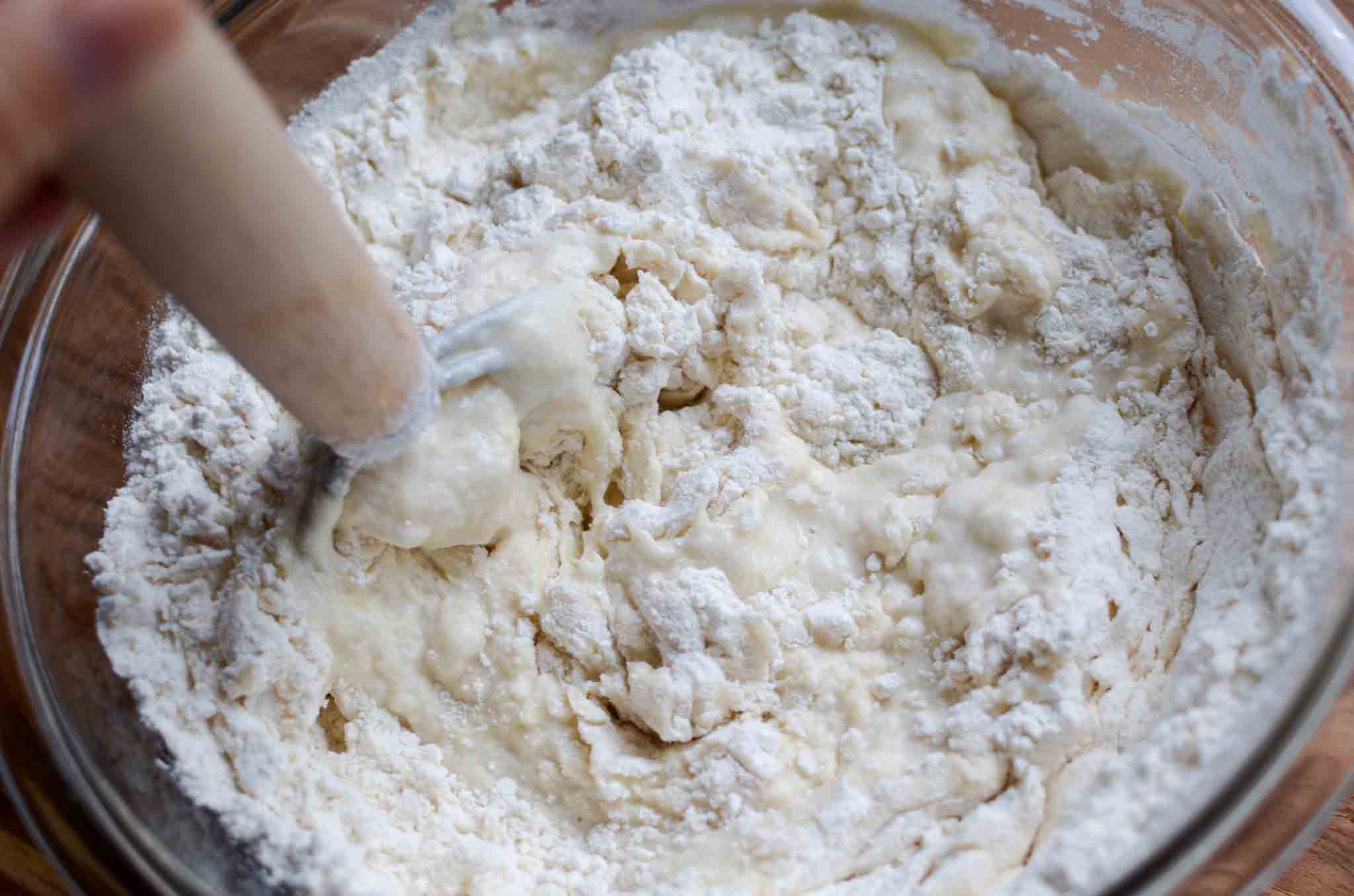 Mixing sourdough bread dough in a glass bowl
