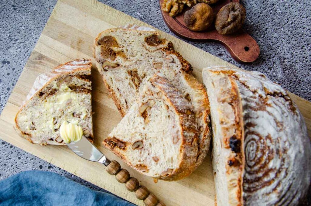 cut slices of walnut and fig sourdough bread on a cutting board