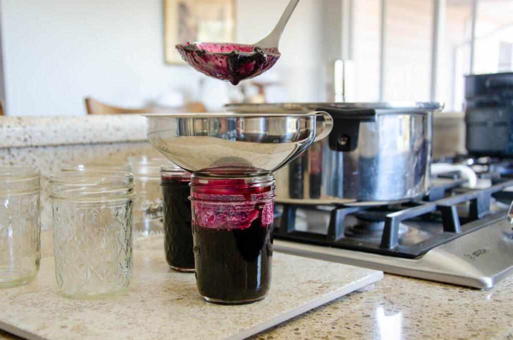 ladling preparing a jar by ladling food into it for water bath canning