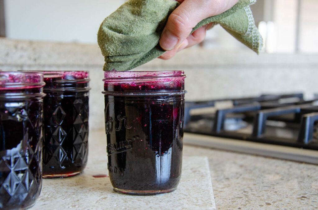 wiping the rim of the jar with a clean cloth