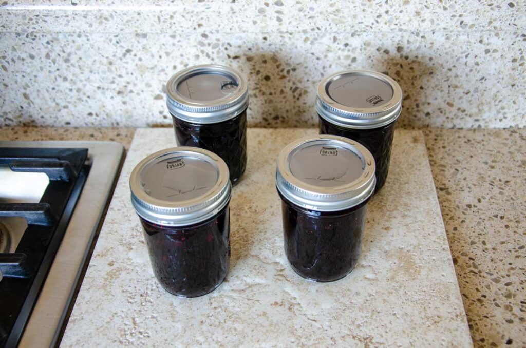jars of jam on a hot plate after water bath canning